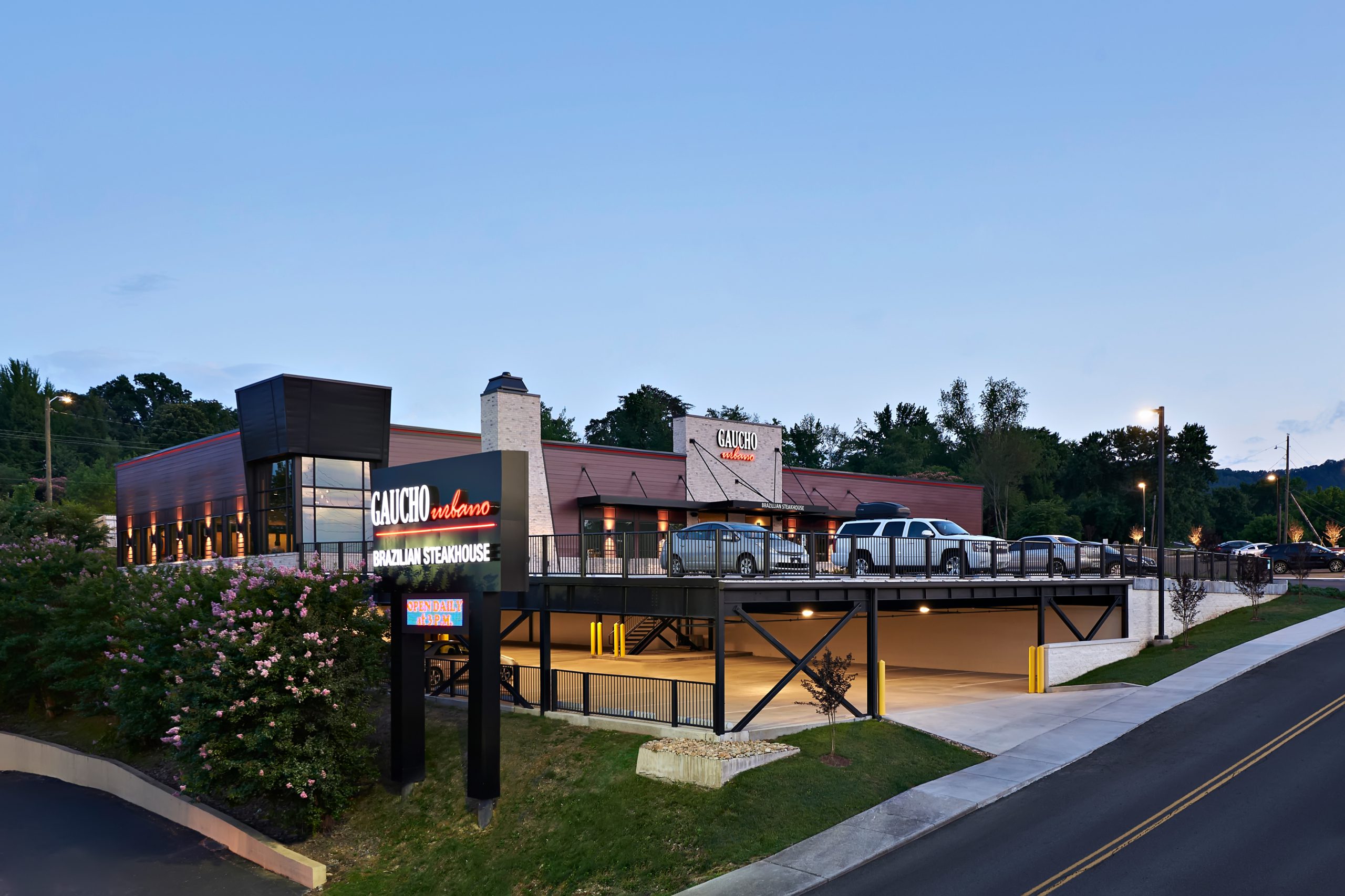 Gaucho Urbano Brazilian Steakhouse exterior designed and built by George Ewart, a top commercial architect firm in Knoxville, TN, featuring modern architecture, outdoor dining area, and illuminated signage.