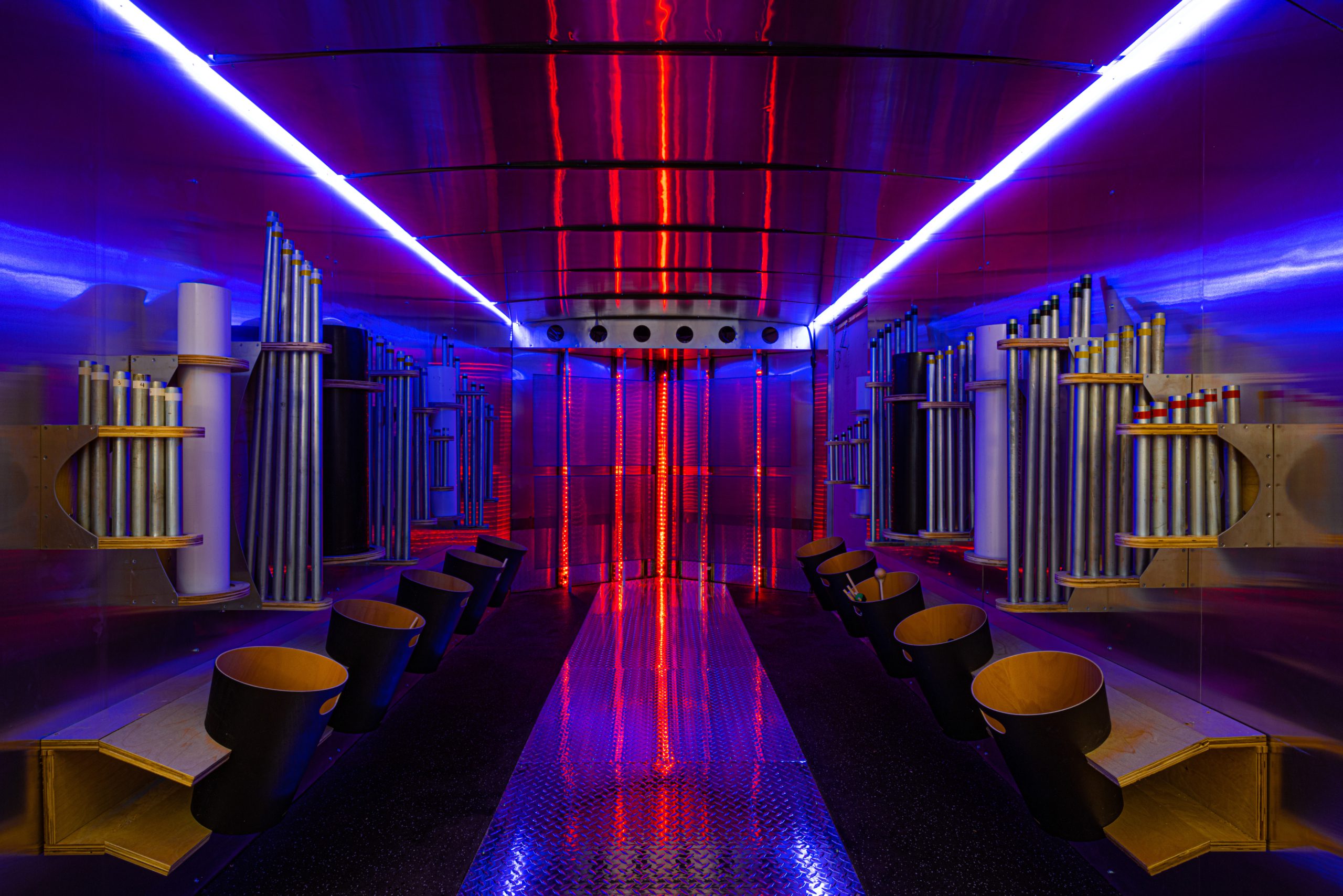 Interior of a colorful architectural space featuring illuminated pipes and seating, designed and built by George Ewart, a top commercial architect firm in Knoxville, TN.