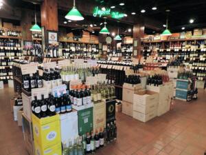 Interior of Ashe’s Wines & Spirits in Knoxville, TN, showcasing a diverse selection of wines and spirits arranged on wooden shelves, designed and built by George Ewart, a top commercial architect firm in Knoxville, TN.