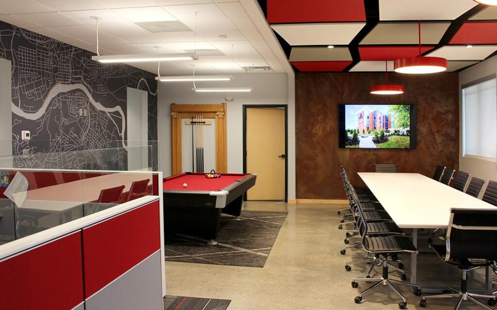 Modern office space featuring a pool table, conference table, and a wall mural of a city map, designed and built by George Ewart, a top commercial architect firm in Knoxville, TN.