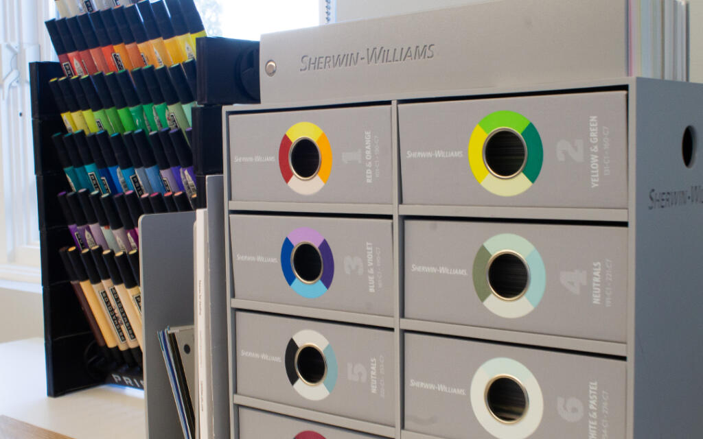 Color swatches and paint samples organized in a Sherwin-Williams display, showcasing design elements relevant to architecture and interior design culture.