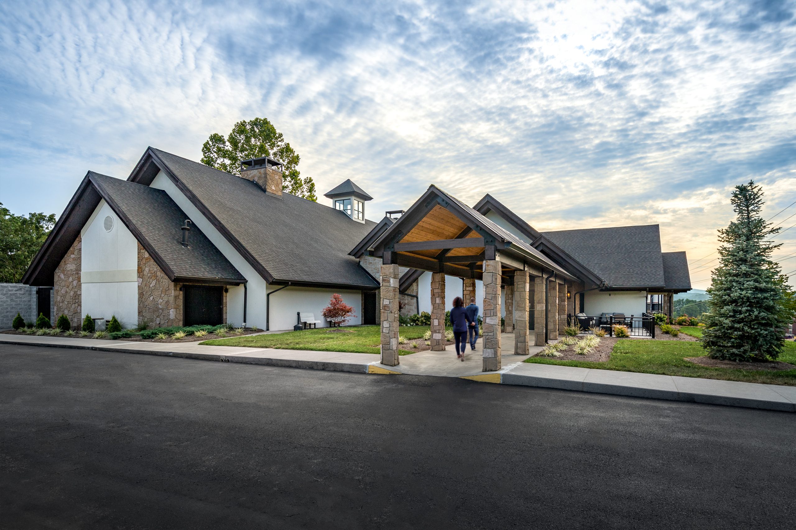 Exterior view of Pizza Rio, a Brazilian-inspired restaurant in Pigeon Forge, Tennessee, showcasing the unique architectural design with a stone and wood facade, a welcoming entrance, and landscaped surroundings, designed and built by George Ewart, a top commercial architect firm in Knoxville, TN.