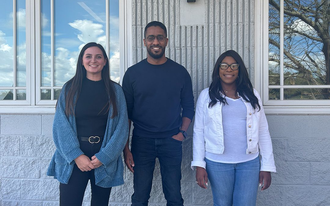 Three new team members of GAE Architecture + Design standing outdoors, showcasing a commitment to creativity and sustainability in commercial architecture.
