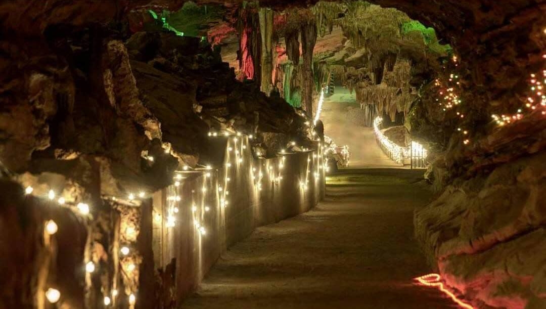 Illuminated pathway inside Cherokee Caverns, featuring colorful lights and natural rock formations, creating an enchanting atmosphere for Halloween-themed events in East Tennessee.