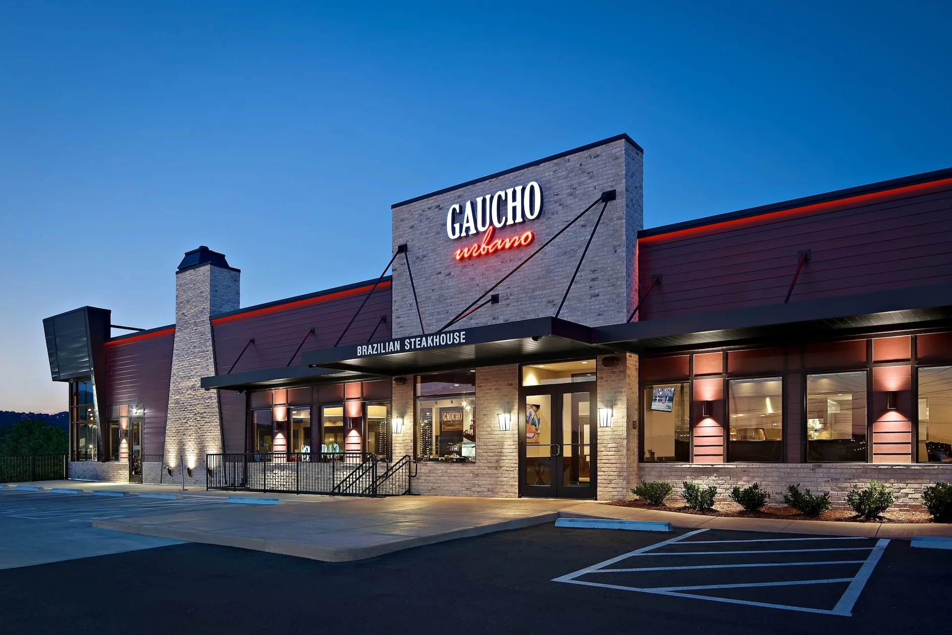 Gaucho Urbano Brazilian steakhouse exterior at dusk, showcasing modern architecture and inviting entrance, designed and built by George Ewart, a top commercial architect firm in Knoxville, TN.