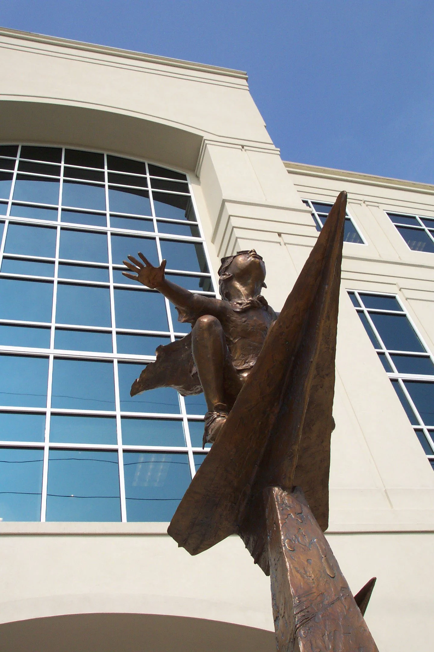 Sculpture of a child reaching out, positioned in front of the Meridian Office Building at Northshore Plaza, Knoxville, TN, showcasing contemporary architectural renovation by commercial architects.