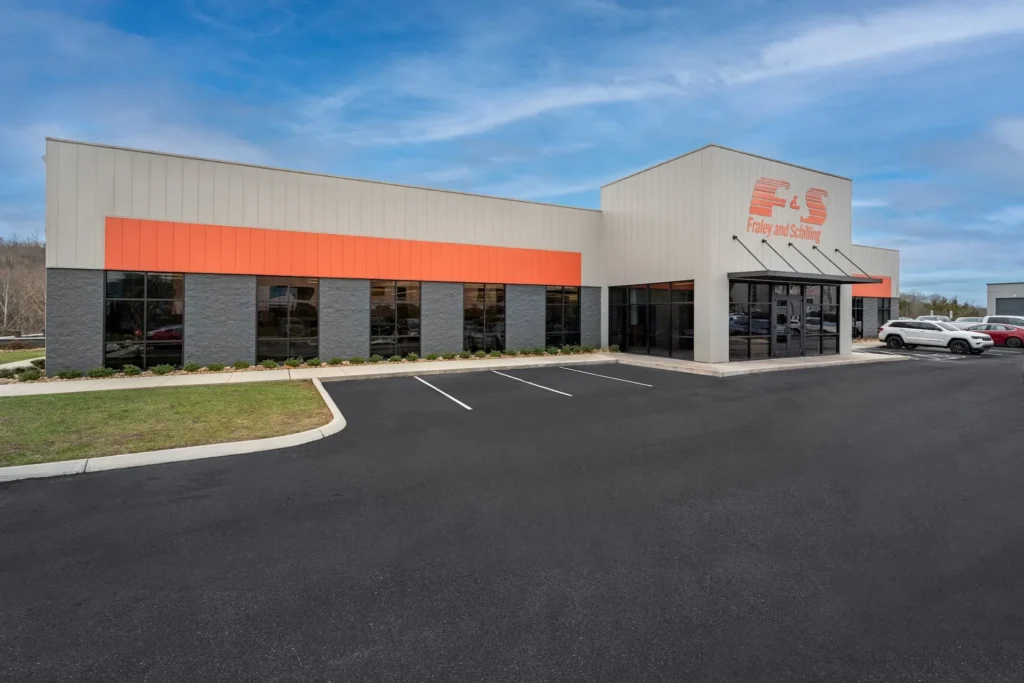 Fraley & Schilling corporate office exterior in Knoxville, TN, featuring modern design elements, large windows, and prominent orange branding, designed and built by George Ewart, a top commercial architect firm in Knoxville, TN.