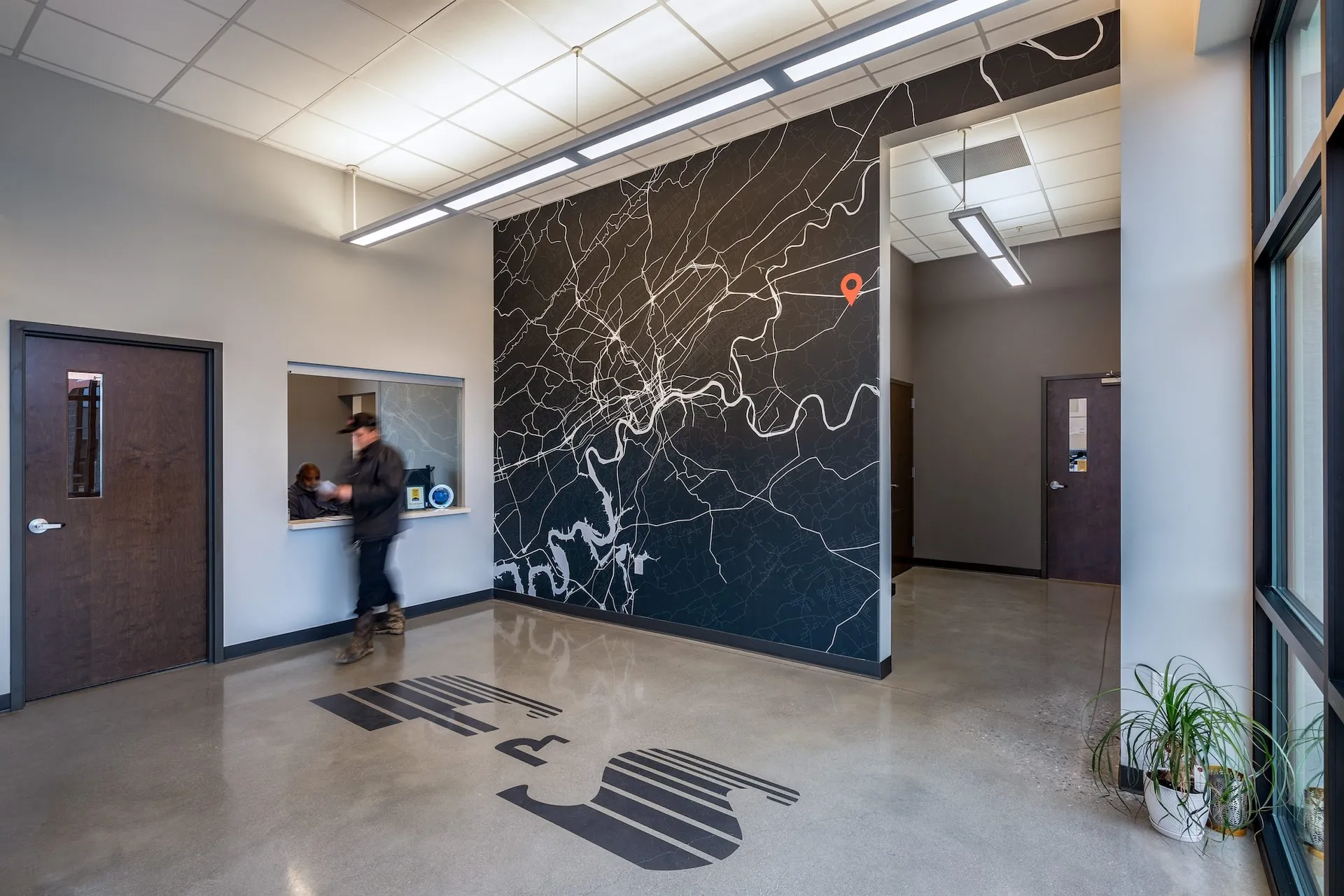 Interior of Fraley & Schilling headquarters in Knoxville, TN, featuring a large wall map design and custom logo on the floor, showcasing modern office layout and branding elements, designed and built by George Ewart, a top commercial architect firm in Knoxville, TN.