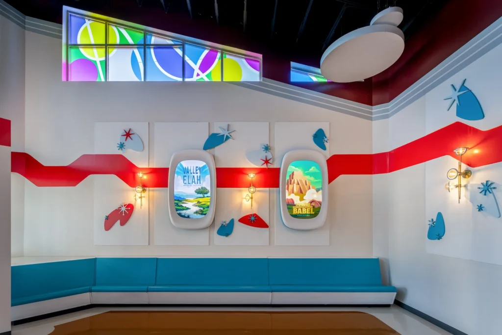 Futuristic lobby design featuring wall displays for "Valley Elah" and "Tower of Babel," with vibrant colors, decorative elements, and seating area, part of the Truth Traveler attraction designed and built by George Ewart, a top commercial architect firm in Knoxville, TN.