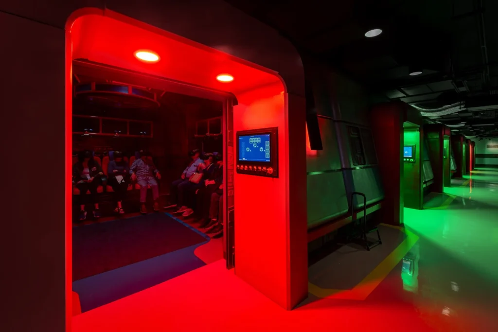 VR pods and glowing light tunnel in immersive attraction designed by GAE Architecture + Design, featuring futuristic elements for the Truth Traveler experience in Pigeon Forge, Tennessee.