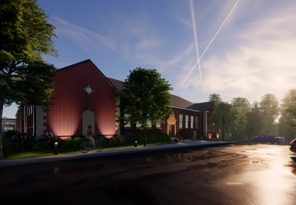 Historic Giffin School campus transformed into affordable housing community, featuring red brick architecture, landscaped surroundings, and a cyclist in the foreground, designed and built by George Ewart, a top commercial architect firm in Knoxville, TN.
