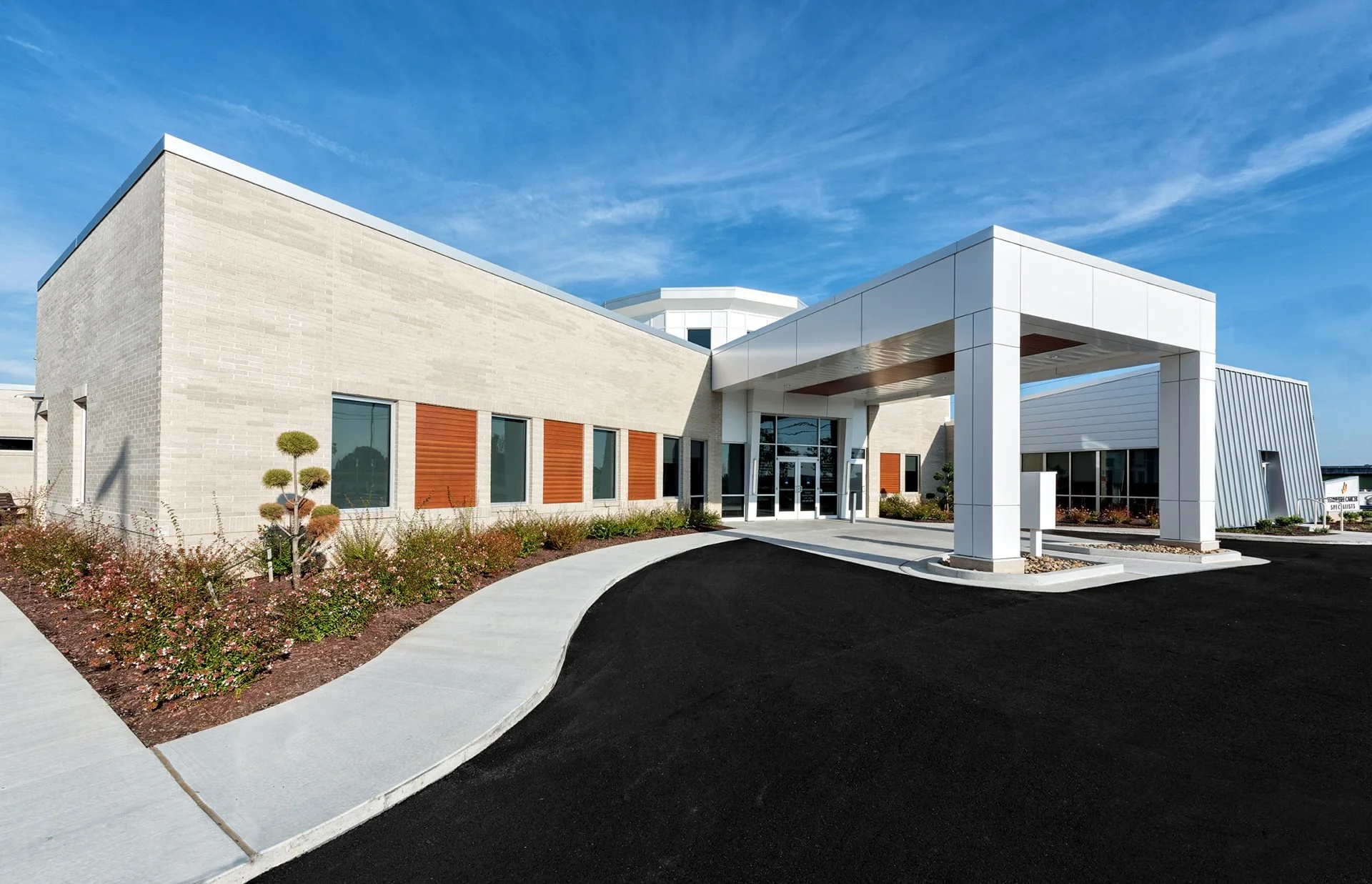 Tennessee Cancer Specialists building entrance showcasing modern architecture, landscaped gardens, and patient-friendly design, emphasizing a calming environment for oncology care, designed and built by George Ewart, a top commercial architect firm in Knoxville, TN.