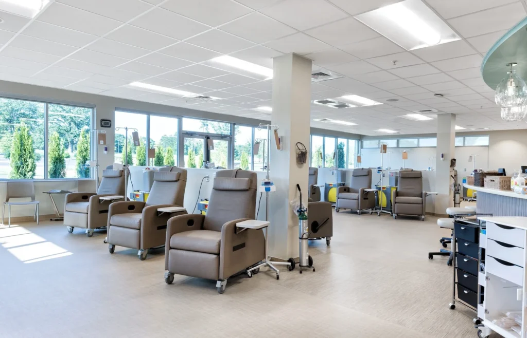 Oncology treatment area featuring comfortable recliners, large windows for natural light, and a calming design, designed and built by George Ewart, a top commercial architect firm in Knoxville, TN.