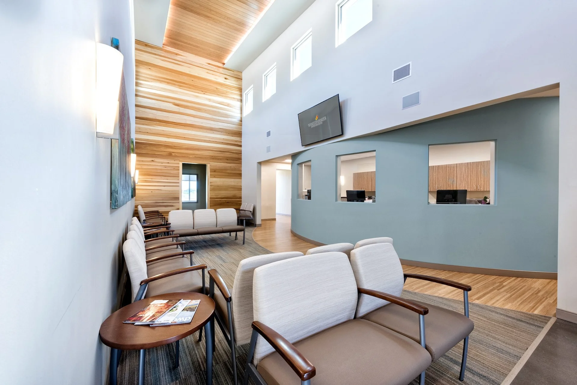 Interior waiting area of Tennessee Cancer Specialists, featuring modern seating, wooden accent walls, and a calming atmosphere designed for oncology care, emphasizing comfort and privacy, by GAE Architecture + Design, commercial architects in Knoxville, TN.
