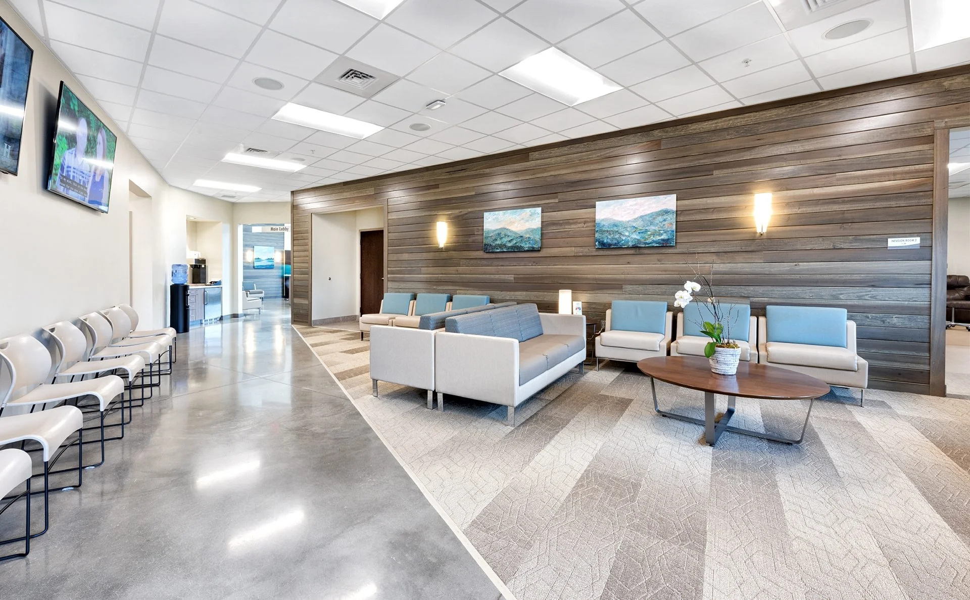 Modern waiting area of Tennessee Cancer Specialists, featuring comfortable seating, natural wood accents, and calming artwork, designed and built by George Ewart, a top commercial architect firm in Knoxville, TN.