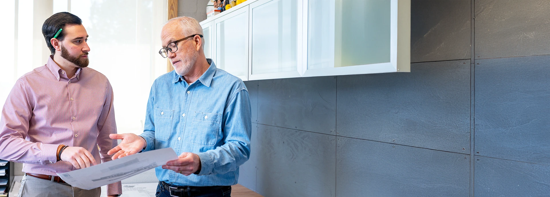 Two architects discussing project plans in a modern office setting, emphasizing collaboration and design process at GAE Architecture + Design, Knoxville, TN.