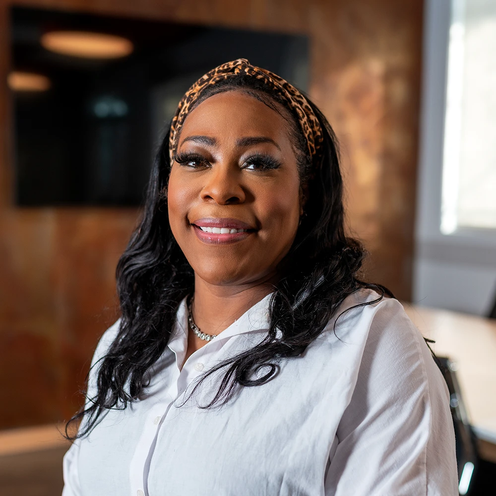 Ashley Howard, Executive Assistant at GAE Architecture + Design, smiling in a professional setting, showcasing her approachable personality and positive demeanor.